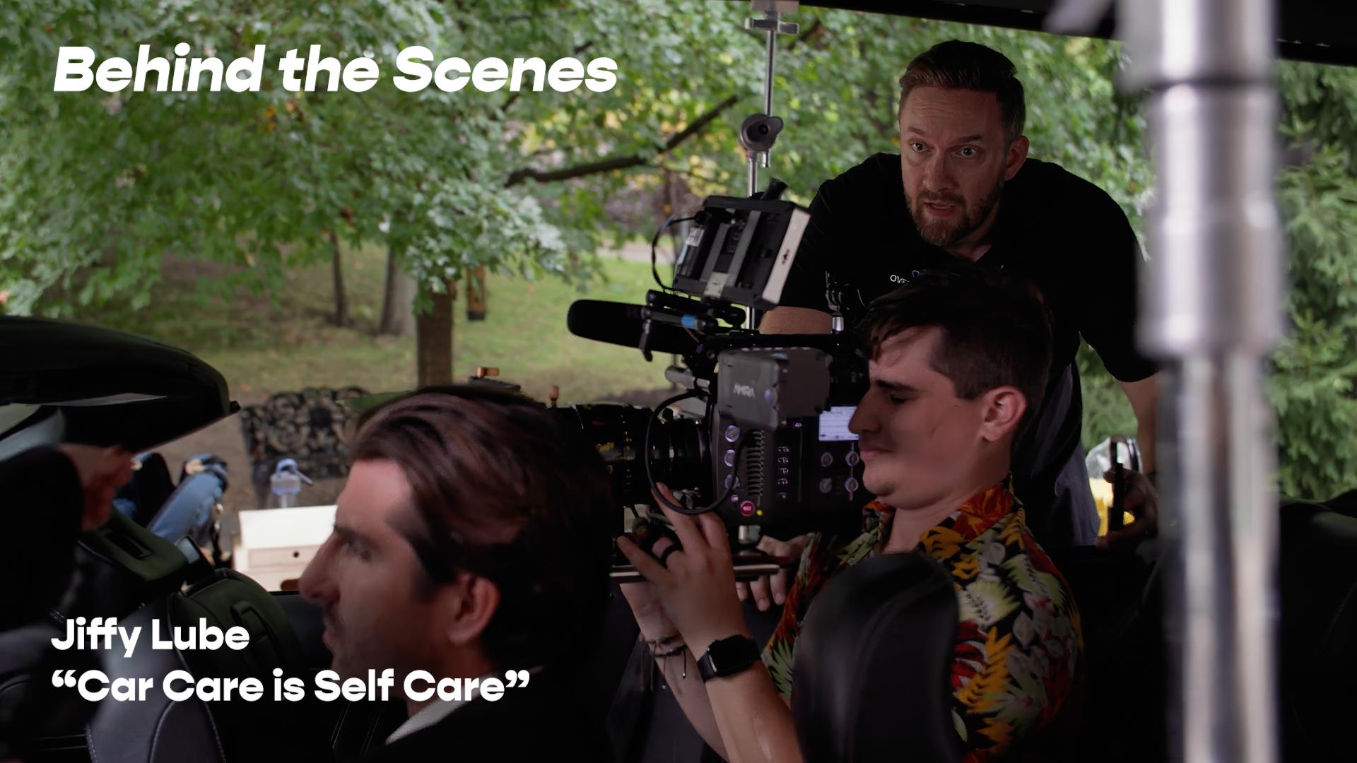 Looping background video from the Michigan Auto Law “The Interrupter” commercial showing two attorneys at a desk during a comedic interruption.